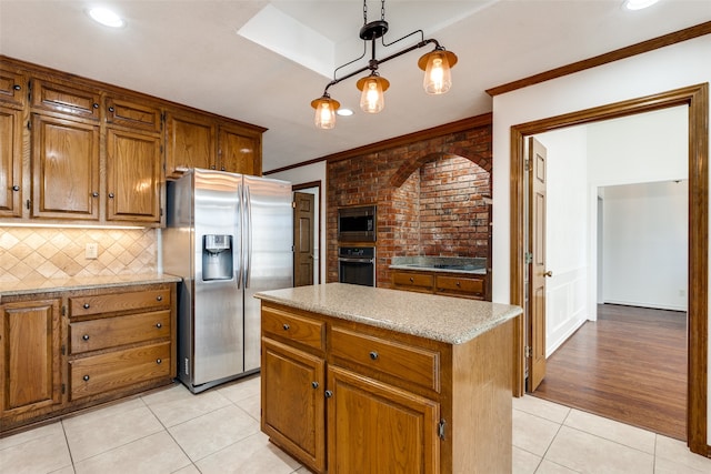 kitchen featuring hanging light fixtures, light wood-type flooring, stainless steel appliances, a kitchen island, and ornamental molding