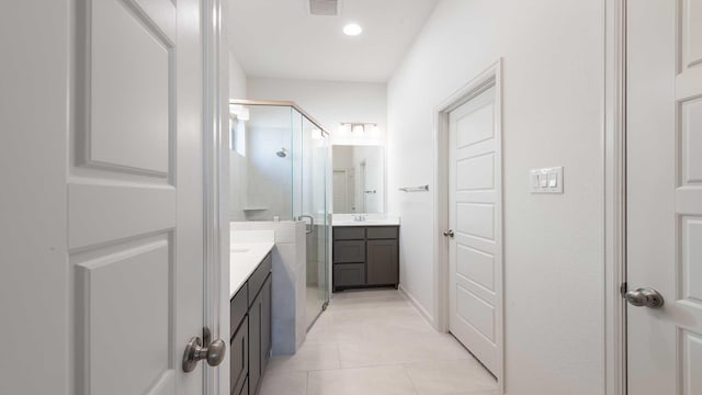 bathroom featuring tile patterned floors, vanity, and a shower with door