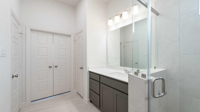 bathroom with tile patterned flooring, vanity, and a shower with door