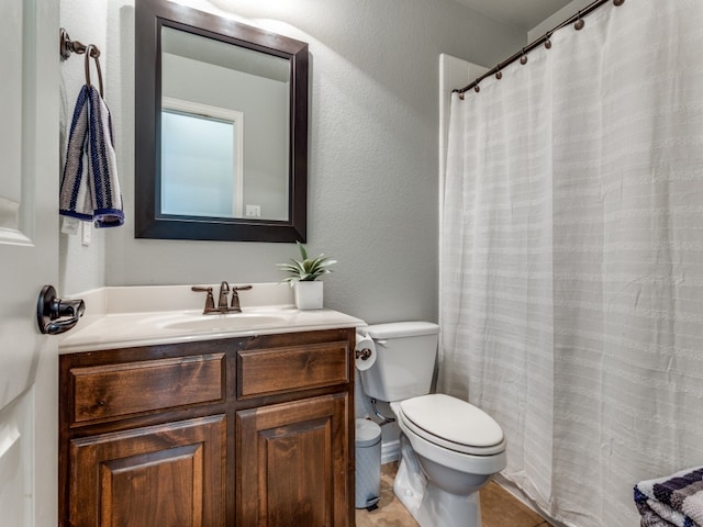 bathroom featuring walk in shower, vanity, tile patterned flooring, and toilet