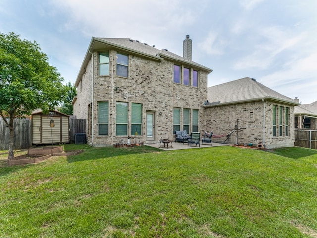 rear view of house with a storage shed, cooling unit, a patio area, and a lawn