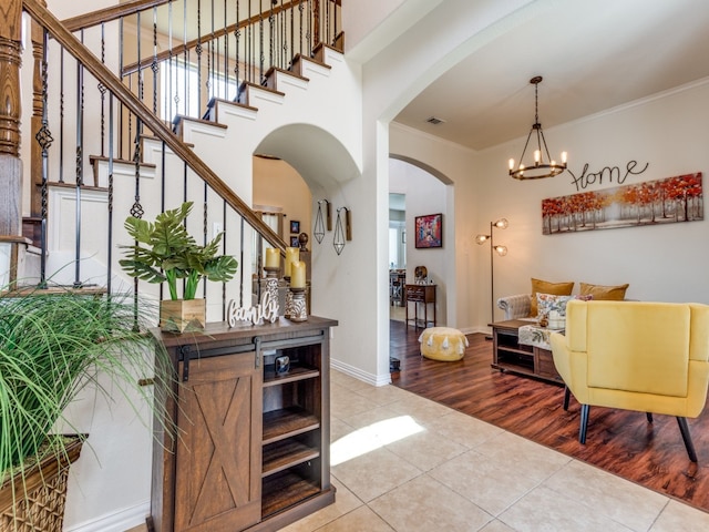 foyer entrance with ornamental molding, a chandelier, and light hardwood / wood-style floors