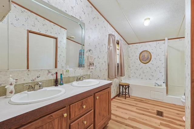 bathroom with tasteful backsplash, a textured ceiling, toilet, dual bowl vanity, and wood-type flooring