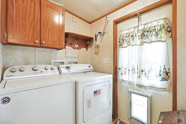 laundry room featuring crown molding, a textured ceiling, washing machine and clothes dryer, and cabinets