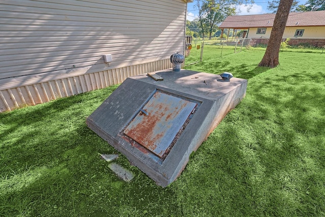 entry to storm shelter featuring a lawn