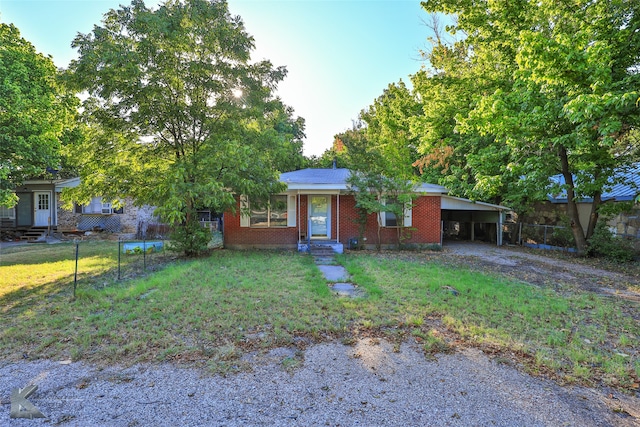 ranch-style house featuring a carport and a front yard