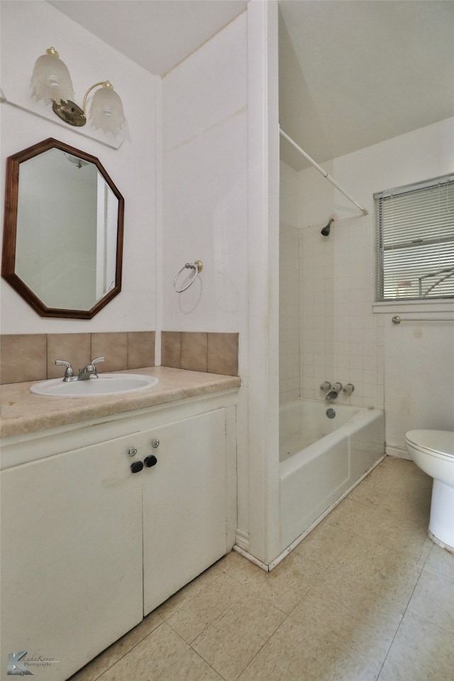 full bathroom featuring vanity, tiled shower / bath combo, toilet, and tile patterned flooring