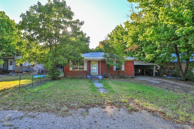 ranch-style home featuring a front yard and a carport