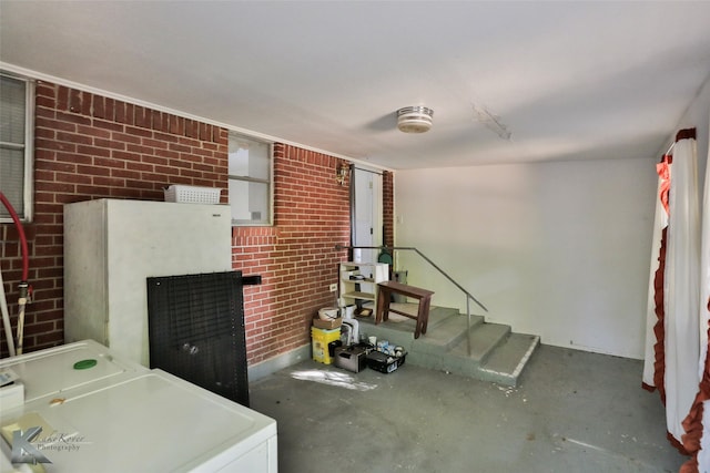 interior space with independent washer and dryer and brick wall