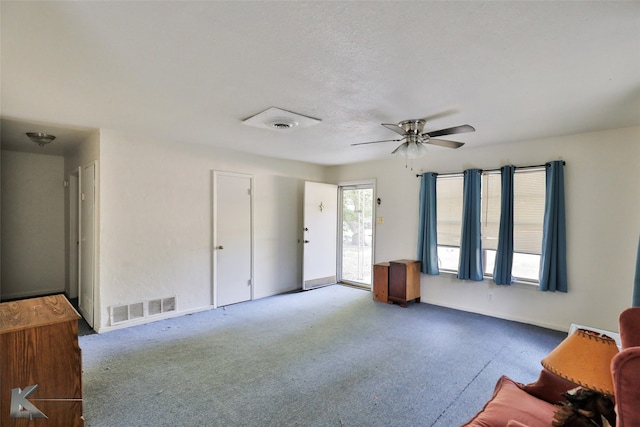 living room with ceiling fan and a textured ceiling