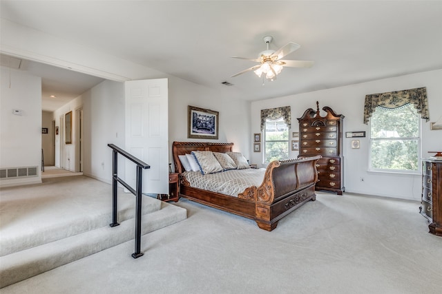 bedroom with light carpet, ceiling fan, and multiple windows