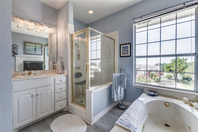 bathroom with hardwood / wood-style flooring, vanity, and independent shower and bath