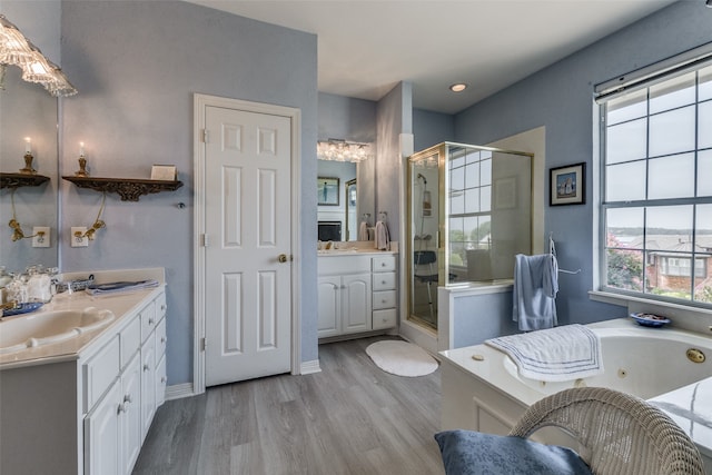 bathroom with shower with separate bathtub, dual vanity, and hardwood / wood-style flooring