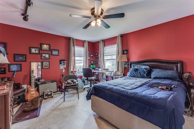 carpeted bedroom with rail lighting, a textured ceiling, and ceiling fan