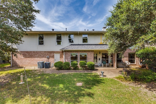 rear view of property with a patio area, central AC unit, and a yard