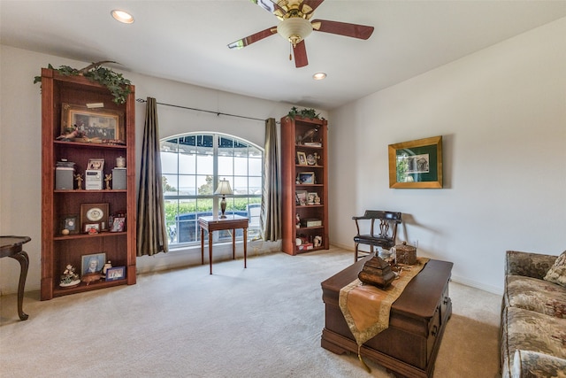 sitting room with ceiling fan and light carpet