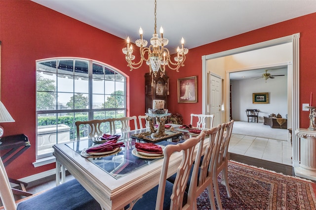 tiled dining space with ceiling fan with notable chandelier