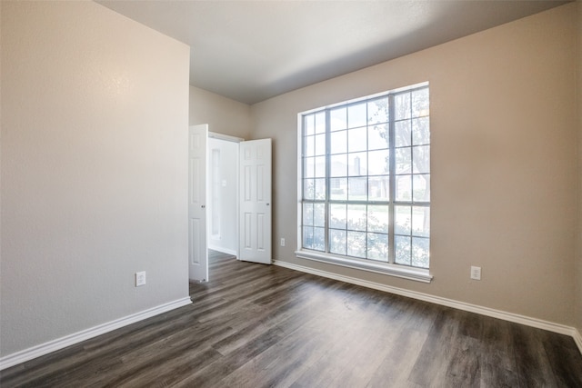 unfurnished room with dark wood-type flooring and plenty of natural light