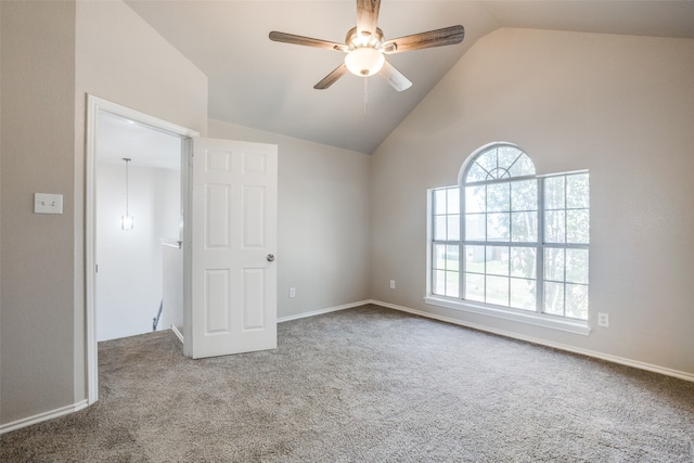 carpeted spare room with ceiling fan, a wealth of natural light, and high vaulted ceiling