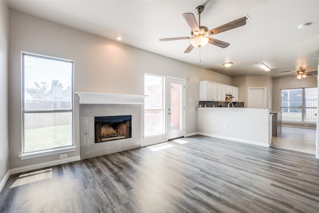 unfurnished living room with hardwood / wood-style floors, ceiling fan, and a wealth of natural light