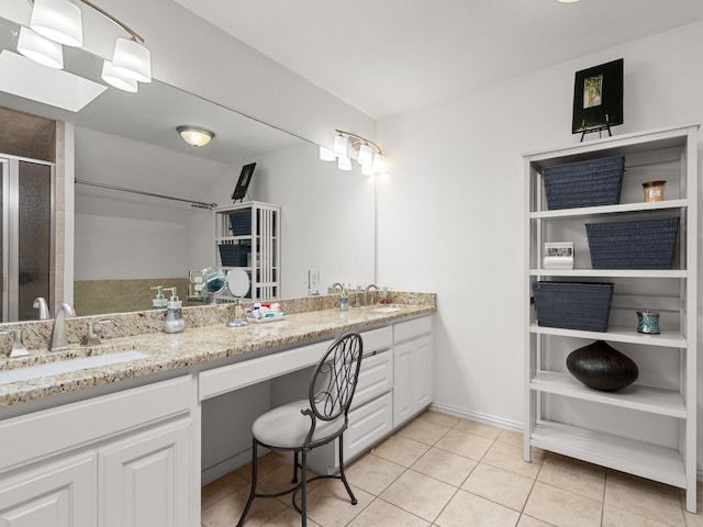 bathroom featuring tile patterned flooring, a sink, a shower stall, and double vanity