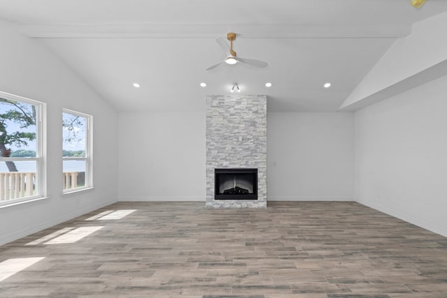 unfurnished living room featuring ceiling fan, a fireplace, vaulted ceiling, and wood-type flooring