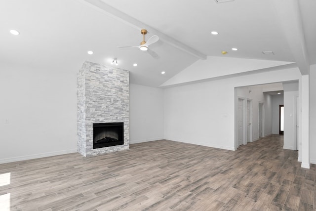 unfurnished living room featuring hardwood / wood-style floors, a fireplace, beam ceiling, and ceiling fan