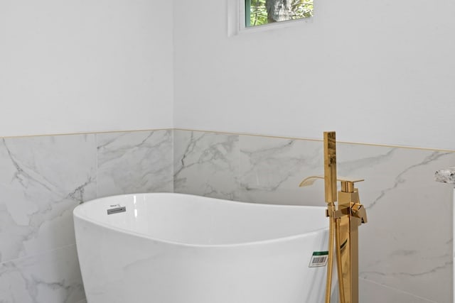 bathroom with tile walls and a bath