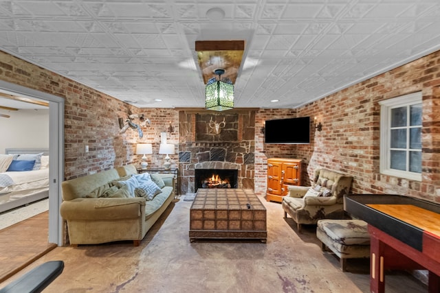 living room with concrete floors, brick wall, and a fireplace