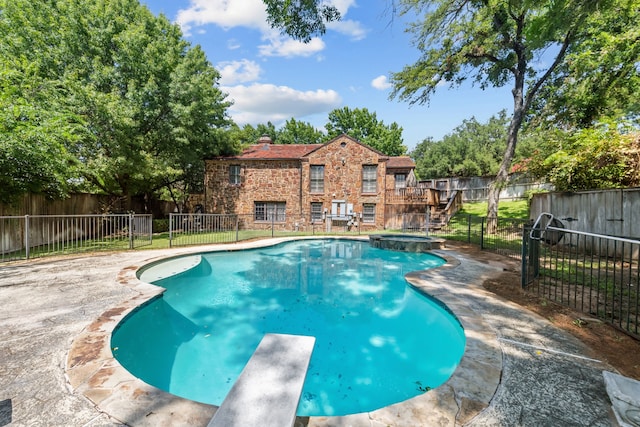 view of pool featuring an in ground hot tub and a diving board