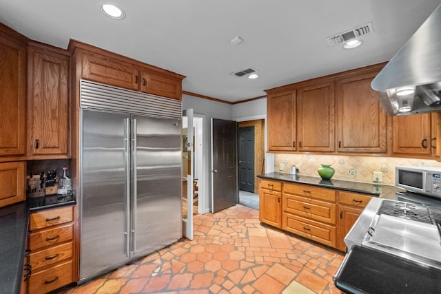 kitchen featuring backsplash, appliances with stainless steel finishes, exhaust hood, and ornamental molding