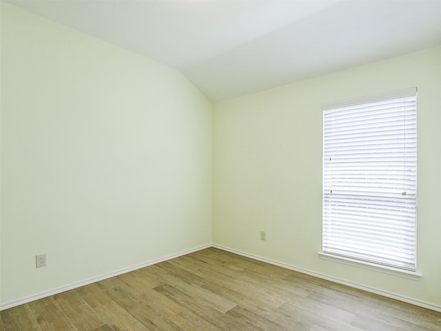 unfurnished room with light hardwood / wood-style flooring, a wealth of natural light, and lofted ceiling