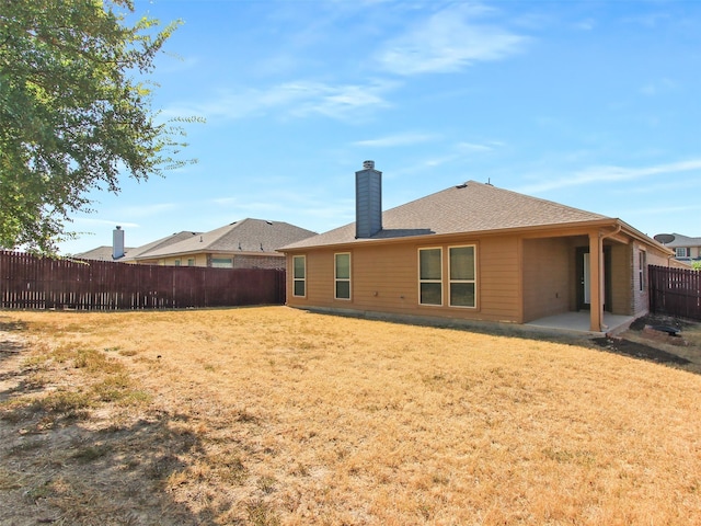 back of property featuring a lawn and a patio area