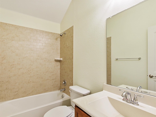 full bathroom featuring lofted ceiling, vanity, tiled shower / bath, and toilet