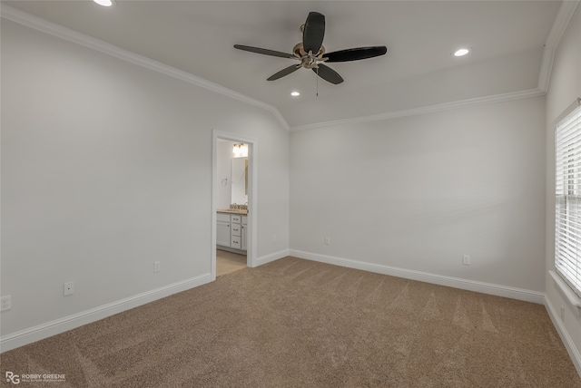 carpeted empty room with crown molding, vaulted ceiling, and ceiling fan