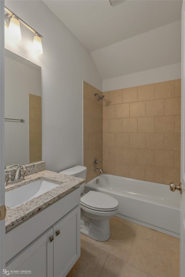 full bathroom with vanity, lofted ceiling, tile patterned flooring, toilet, and tiled shower / bath