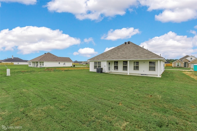 rear view of house with a yard and central air condition unit