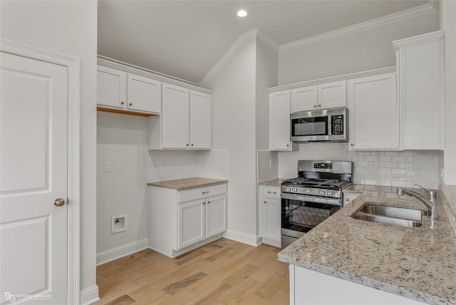 kitchen featuring stainless steel appliances, white cabinetry, light hardwood / wood-style floors, and sink