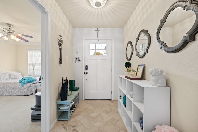 carpeted entrance foyer with plenty of natural light, ceiling fan, and crown molding