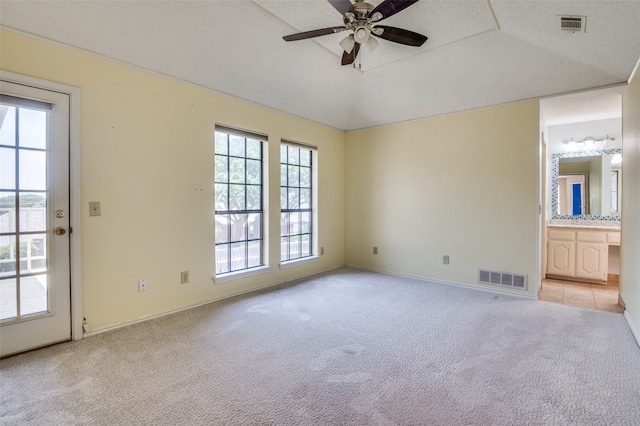 carpeted spare room with ceiling fan and vaulted ceiling