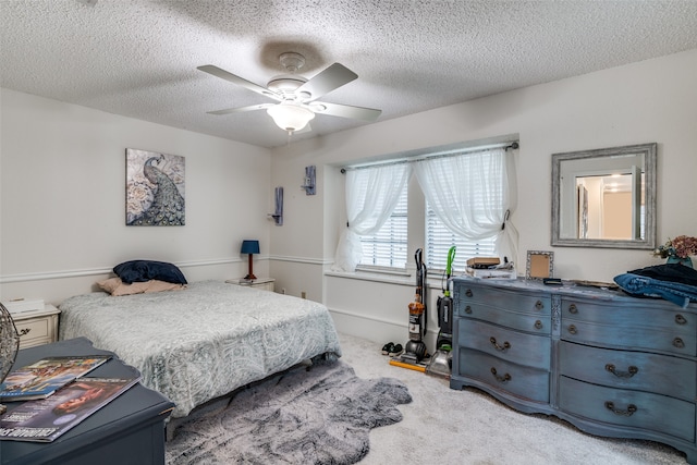 carpeted bedroom featuring a textured ceiling and ceiling fan