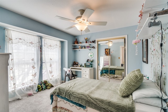 carpeted bedroom featuring ceiling fan and a closet