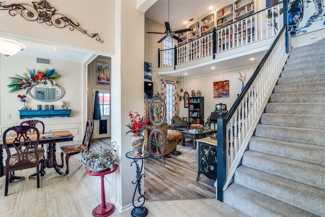 foyer featuring a high ceiling, ceiling fan, and hardwood / wood-style flooring