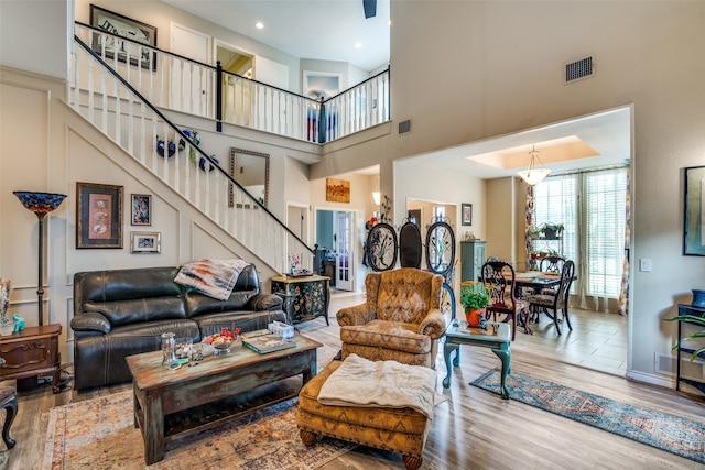 living room featuring a towering ceiling and hardwood / wood-style flooring