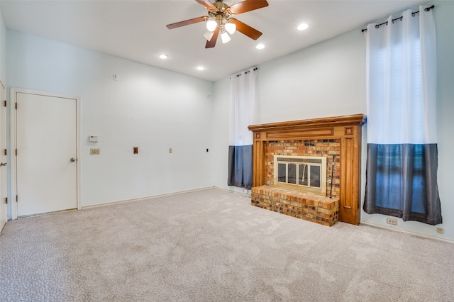 unfurnished living room with a brick fireplace, light carpet, and ceiling fan