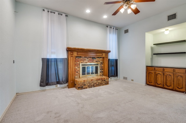 unfurnished living room with light carpet, ceiling fan, and a brick fireplace