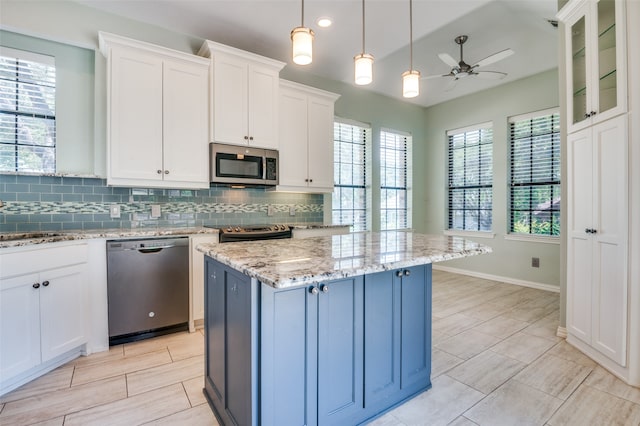 kitchen featuring white cabinetry, ceiling fan, appliances with stainless steel finishes, and a kitchen island