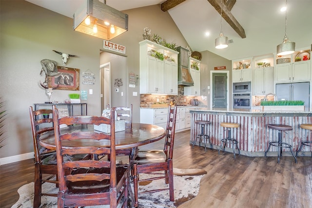 dining area with beam ceiling, dark hardwood / wood-style flooring, and high vaulted ceiling