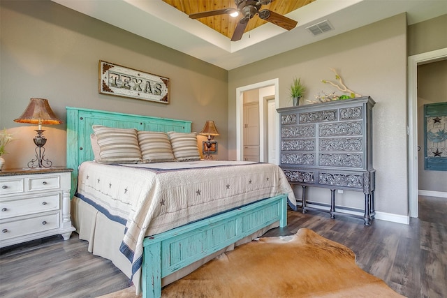 bedroom with ceiling fan, dark hardwood / wood-style floors, and a raised ceiling