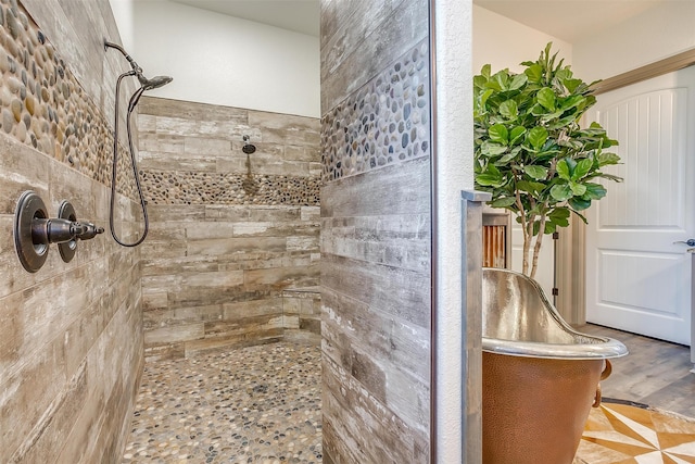 bathroom featuring wood-type flooring and a tile shower